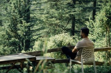 a man sitting on a chair in the woods