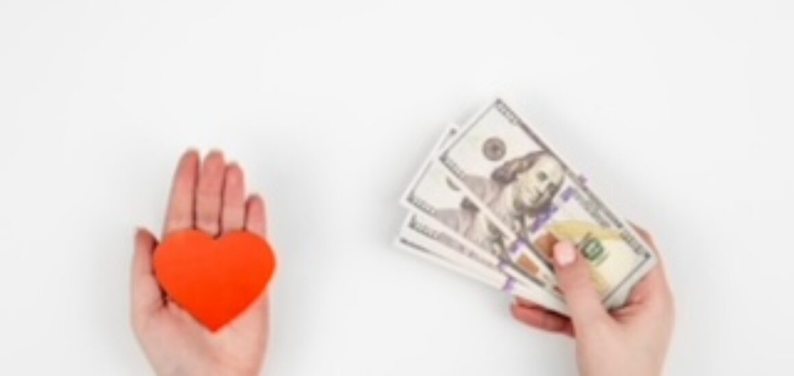 Hand with paper heart and a gift box on a white background isolated, flat lay.