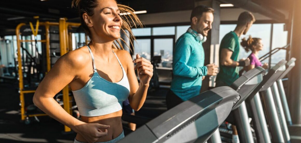 Happy,Athletic,People,Jogging,On,Treadmills,In,A,Health,Club.