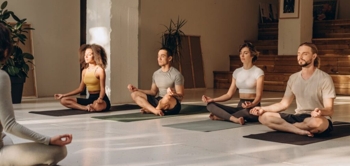 Four,Participants,Trying,Yoga,Practice,With,Instructor