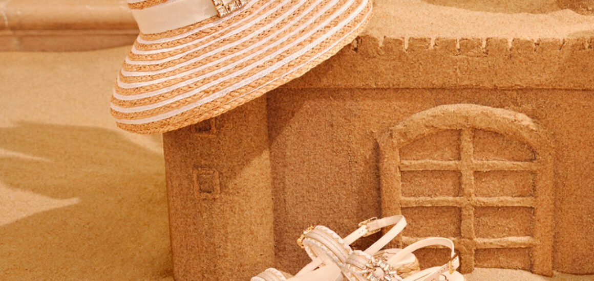 sombrero, sandalia en castillo de arena